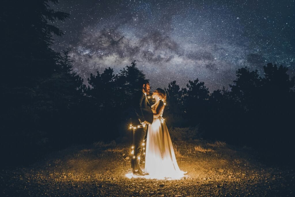 man and woman standing on floor surrounded by yellow string lights